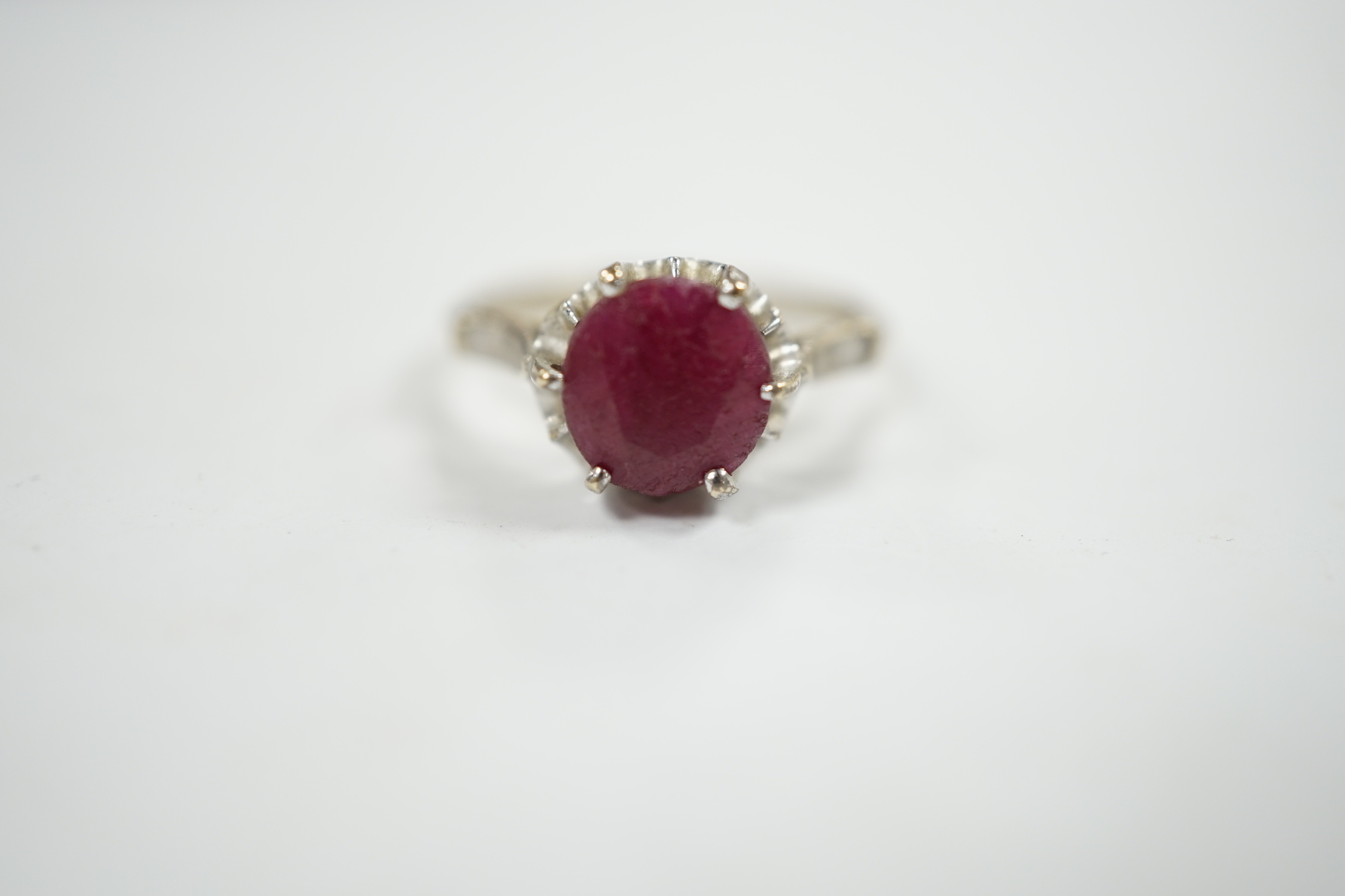 A 750 white metal and solitaire ruby set ring, size M/N, gross weight 3.1 grams.